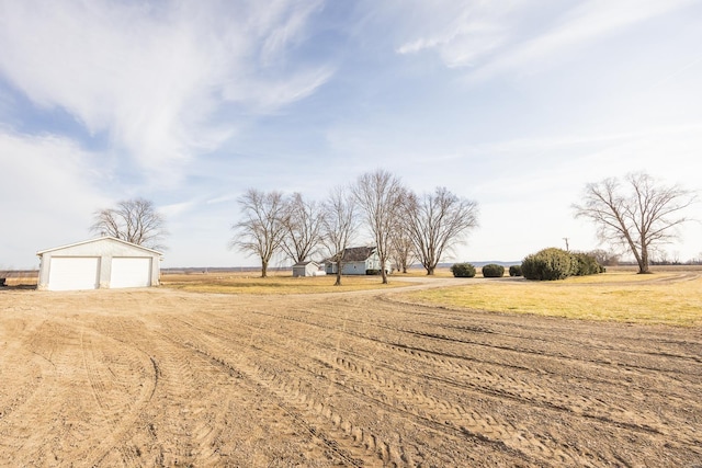 view of yard with a rural view and a garage