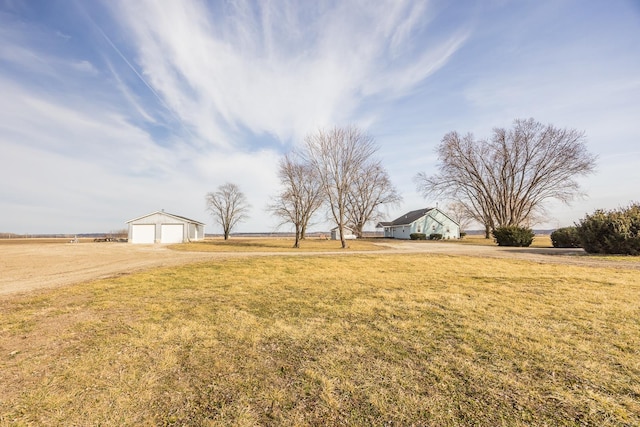 view of yard with a garage and a rural view