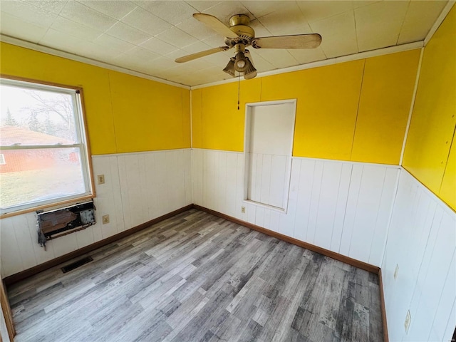 empty room with ornamental molding, ceiling fan, and light hardwood / wood-style flooring