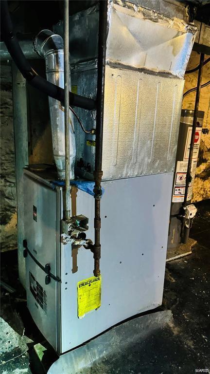 utility room with heating unit and gas water heater