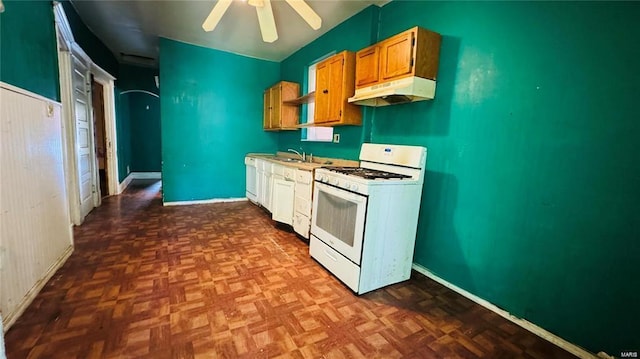 kitchen featuring sink, dark parquet floors, white gas stove, and ceiling fan