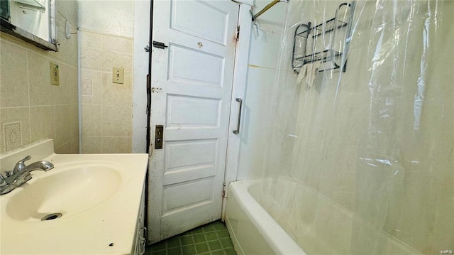 bathroom featuring shower / tub combo, sink, and tile walls