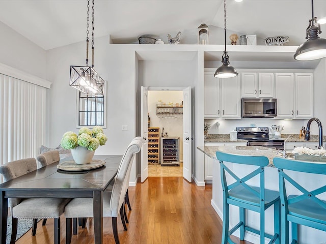 kitchen with pendant lighting, appliances with stainless steel finishes, and white cabinets