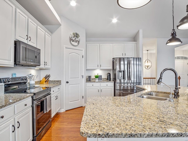 kitchen featuring sink, decorative light fixtures, a center island with sink, appliances with stainless steel finishes, and white cabinets