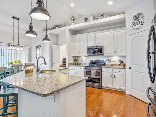 kitchen featuring white cabinetry, appliances with stainless steel finishes, sink, and a kitchen breakfast bar