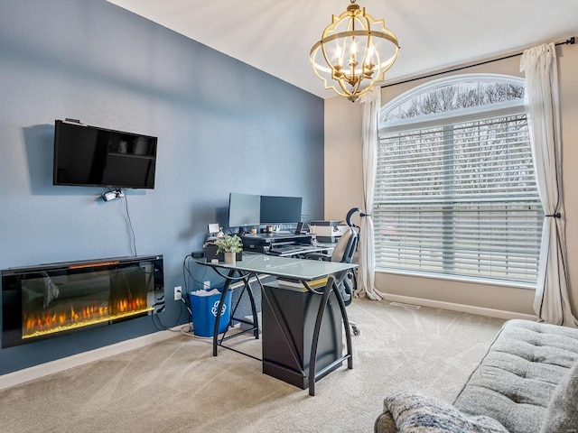 carpeted home office with a chandelier