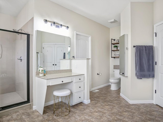 bathroom featuring a shower with door and toilet