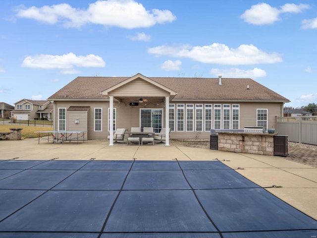 rear view of house featuring an outdoor bar, ceiling fan, and a patio area