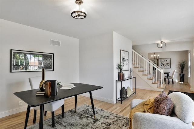 office with a notable chandelier and light hardwood / wood-style floors