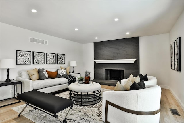 living room with a fireplace and light hardwood / wood-style flooring