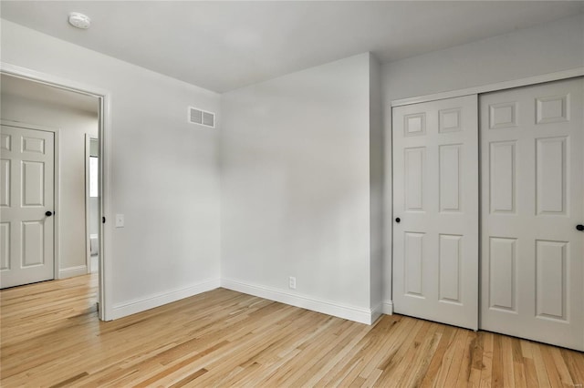 unfurnished bedroom with light hardwood / wood-style floors and a closet