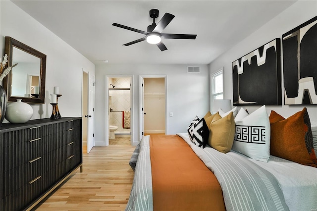 bedroom with a walk in closet, ensuite bath, light hardwood / wood-style flooring, and ceiling fan