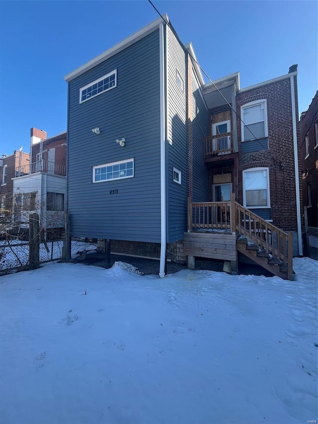 view of snow covered rear of property