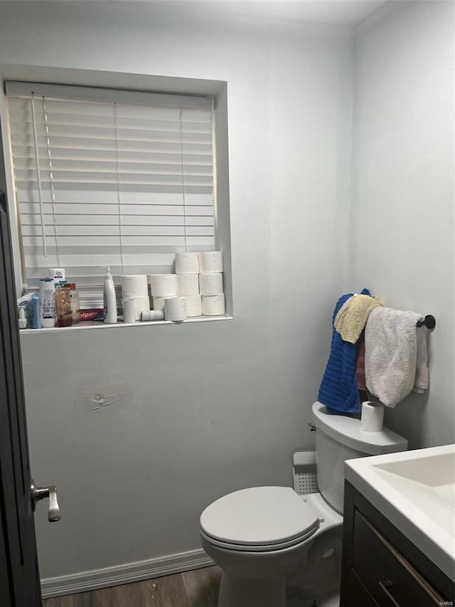 bathroom with hardwood / wood-style flooring, vanity, and toilet