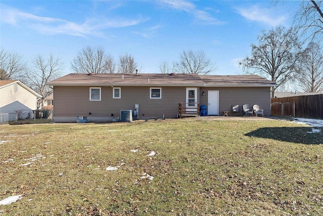 back of house with central AC and a lawn