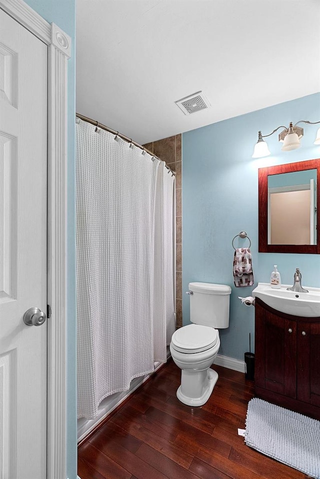 bathroom with vanity, hardwood / wood-style flooring, and toilet