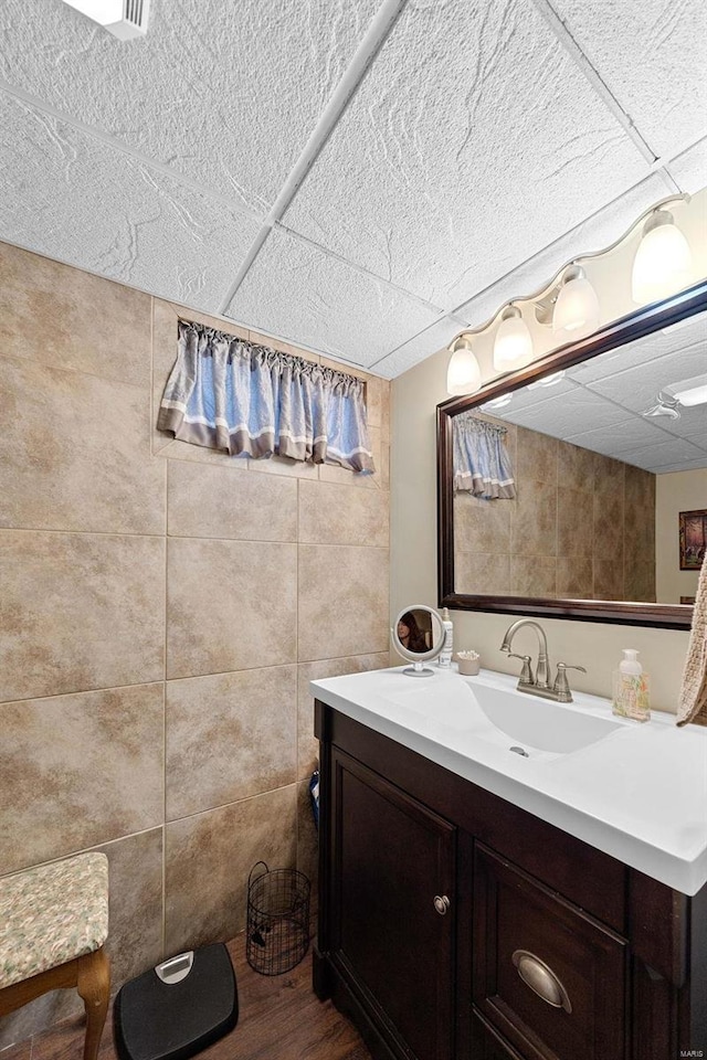 bathroom with a paneled ceiling and vanity