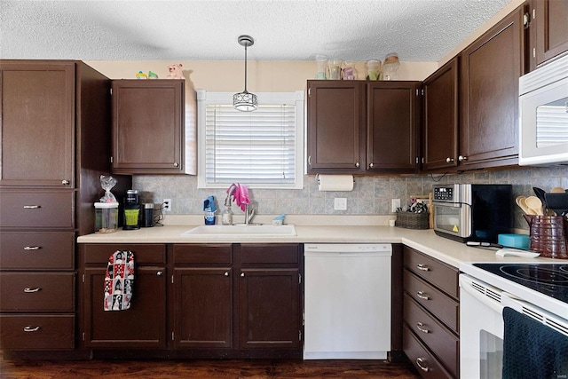 kitchen featuring pendant lighting, white appliances, sink, and decorative backsplash