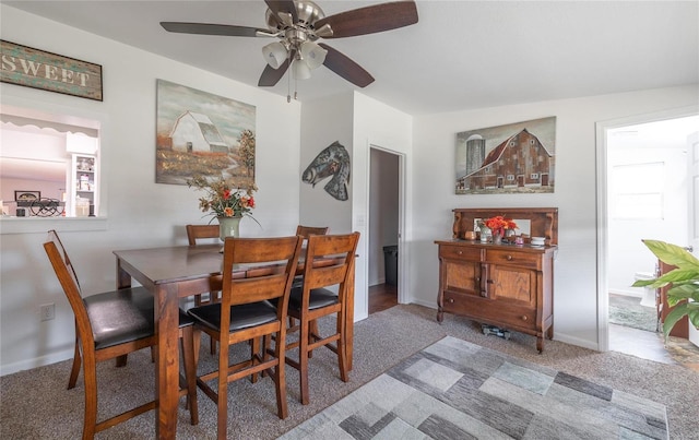 carpeted dining room with ceiling fan