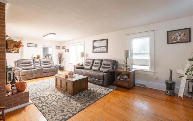 living room featuring wood-type flooring and a wood stove