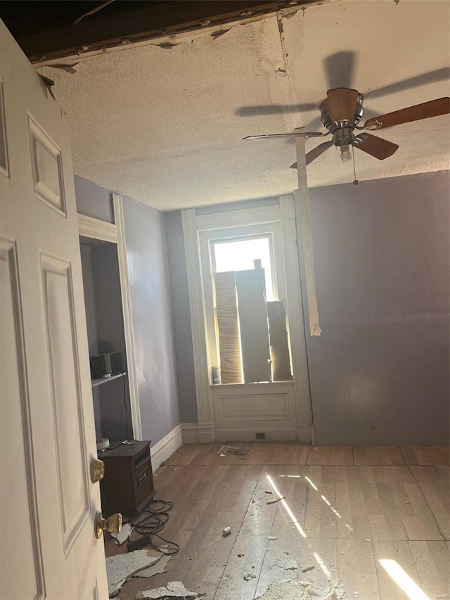 unfurnished room with hardwood / wood-style flooring, ceiling fan, and a textured ceiling