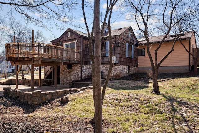 view of side of home with stone siding, stairway, a patio, and a deck