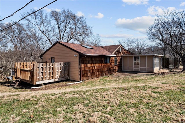 rear view of property with a lawn and fence