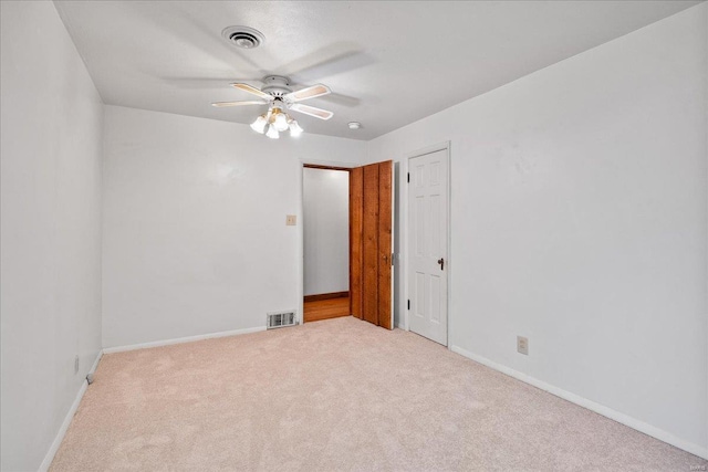 spare room with visible vents, carpet flooring, baseboards, and ceiling fan