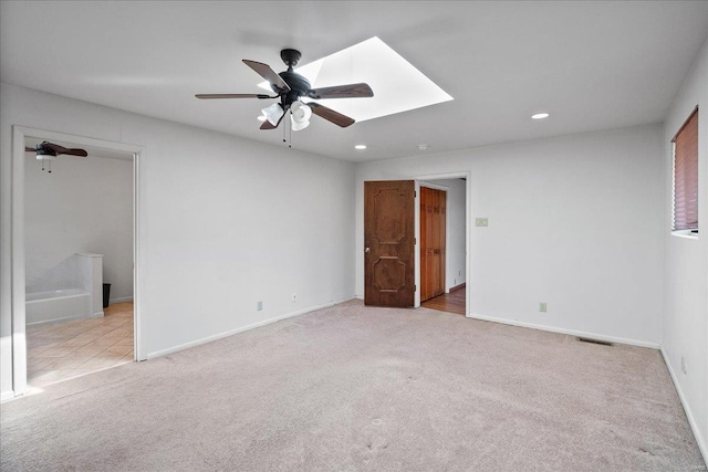 unfurnished bedroom with a ceiling fan, baseboards, carpet floors, a skylight, and recessed lighting