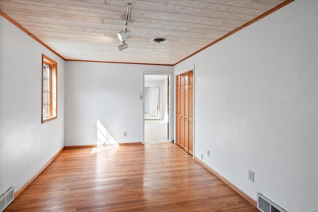 unfurnished room featuring light wood-type flooring, visible vents, and crown molding