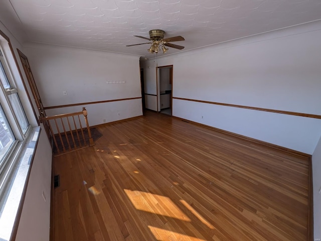 unfurnished room featuring ceiling fan, wood-type flooring, and ornamental molding