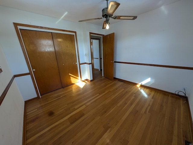 unfurnished bedroom featuring wood-type flooring, a closet, and ceiling fan