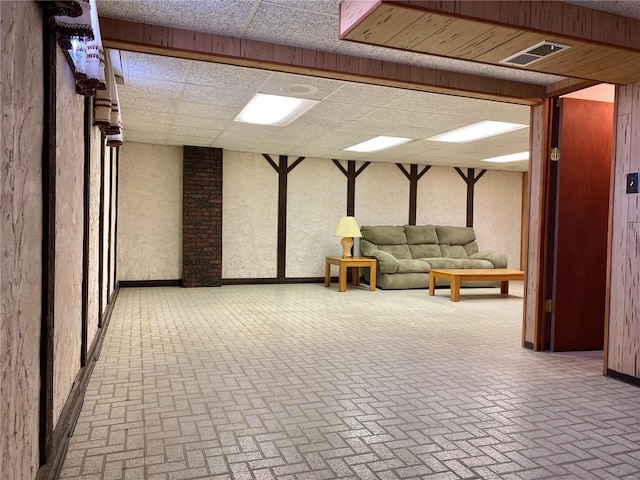 basement with a paneled ceiling