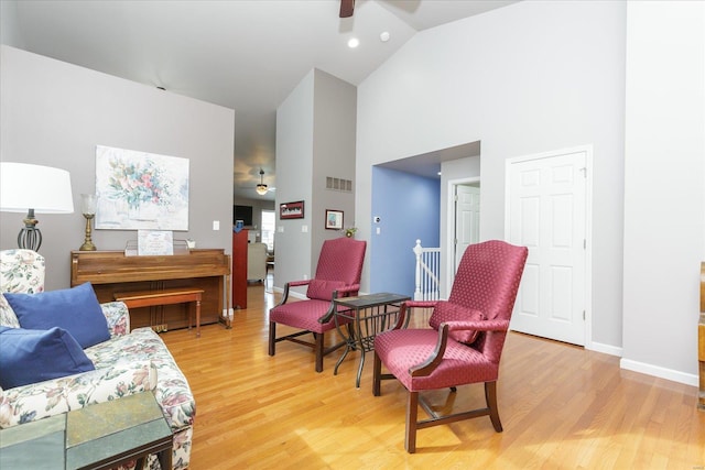 sitting room featuring hardwood / wood-style flooring, high vaulted ceiling, and ceiling fan