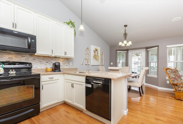 kitchen featuring sink, black appliances, kitchen peninsula, pendant lighting, and white cabinets