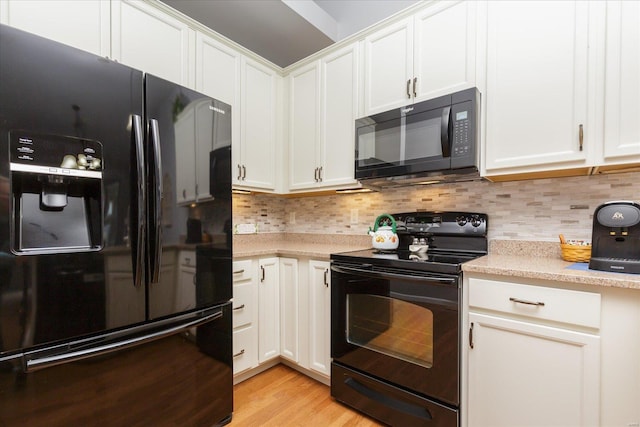 kitchen with tasteful backsplash, black appliances, light hardwood / wood-style floors, and white cabinets