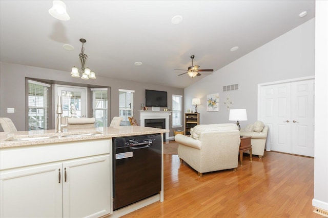 kitchen with sink, white cabinetry, decorative light fixtures, light wood-type flooring, and dishwasher