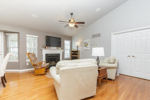 living room with wood-type flooring, high vaulted ceiling, and ceiling fan