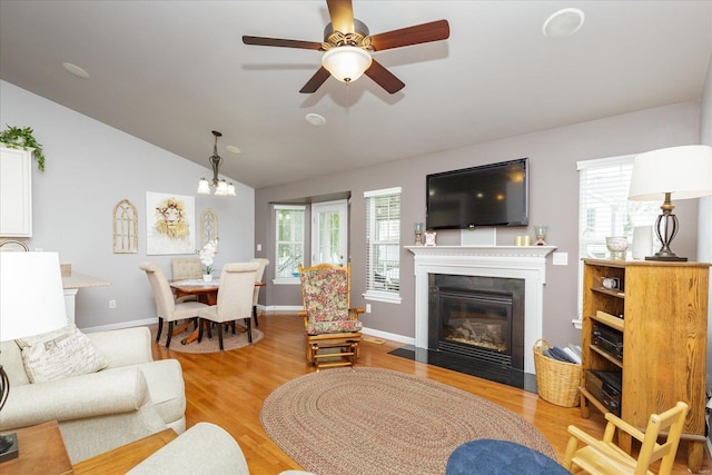 living room featuring ceiling fan, vaulted ceiling, and light hardwood / wood-style flooring