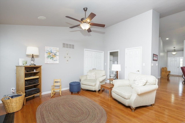 living room with high vaulted ceiling, hardwood / wood-style floors, and ceiling fan