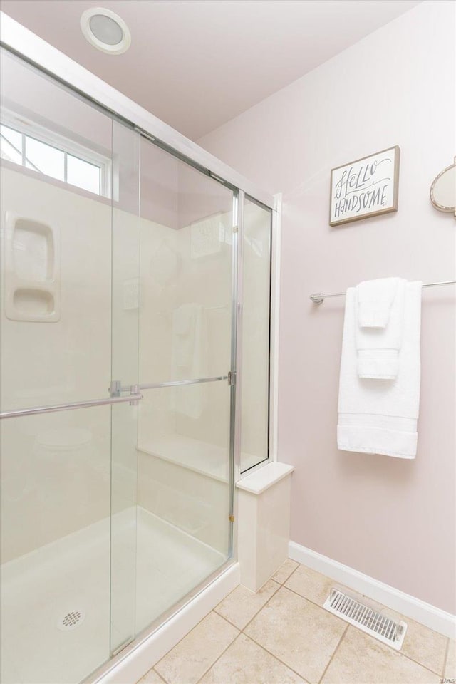 bathroom with walk in shower and tile patterned flooring