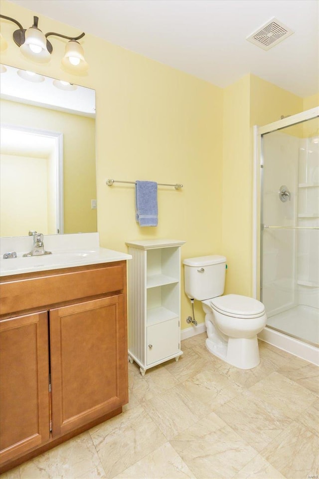 bathroom with vanity, toilet, and a shower with shower door