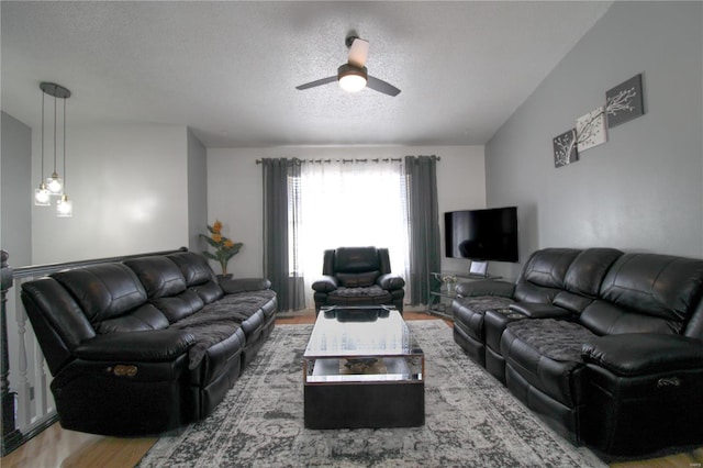 living room featuring wood-type flooring, a textured ceiling, and ceiling fan