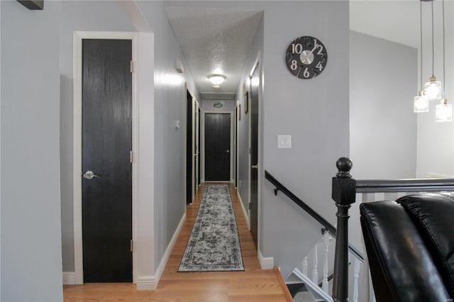 hallway with wood-type flooring and a textured ceiling