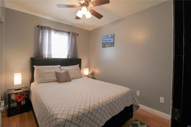 bedroom with ceiling fan and wood-type flooring