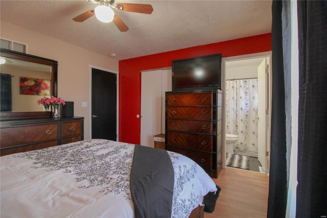 bedroom featuring connected bathroom, ceiling fan, light hardwood / wood-style floors, and a textured ceiling