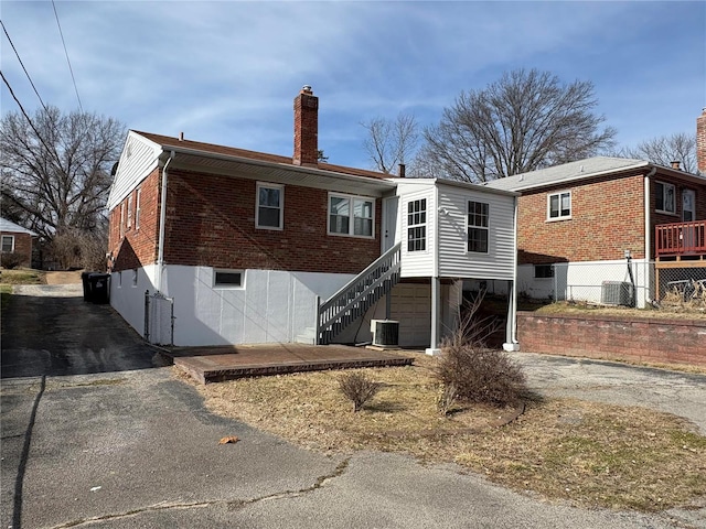 rear view of house featuring cooling unit and a garage