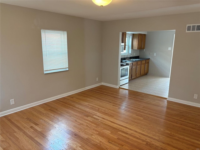 interior space featuring sink, light hardwood / wood-style floors, and stainless steel stove