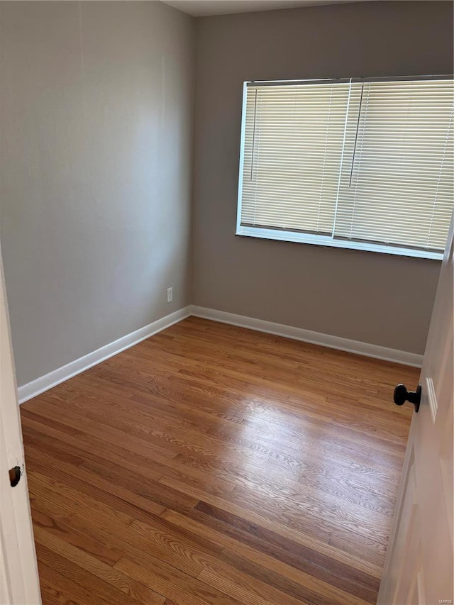 unfurnished room with hardwood / wood-style flooring