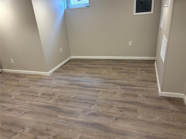 basement featuring hardwood / wood-style flooring and electric panel